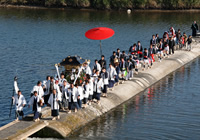 写真：伝統芸能の行列が橋を渡っている